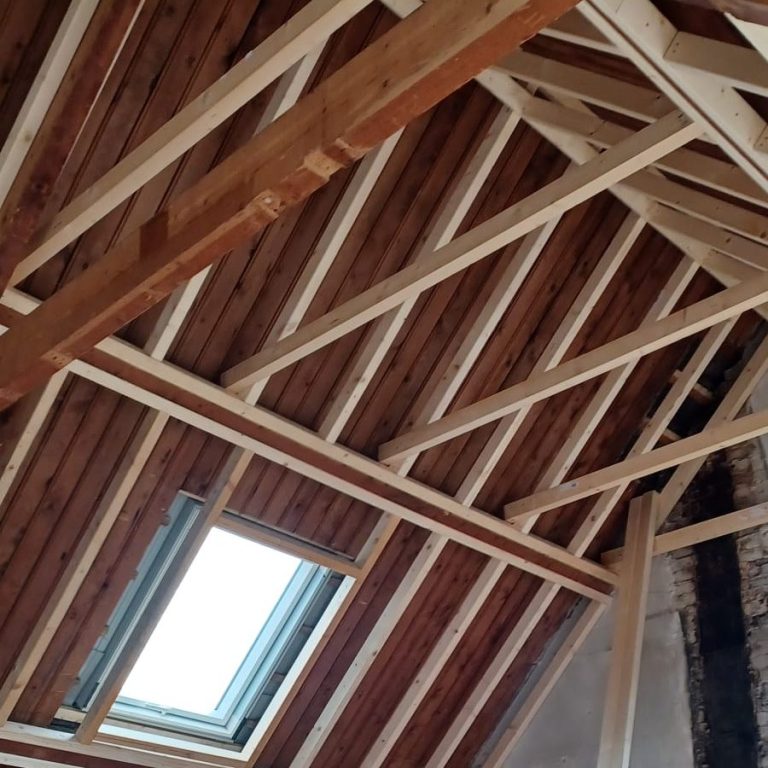 Houten dakconstructie met lichtkoepel en zichtbare balken.