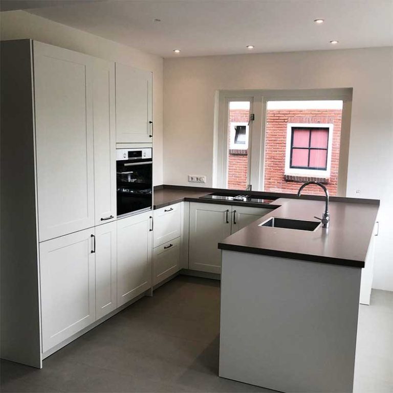 Moderne keuken met witte kasten, een aanrecht en ingebouwde apparatuur.